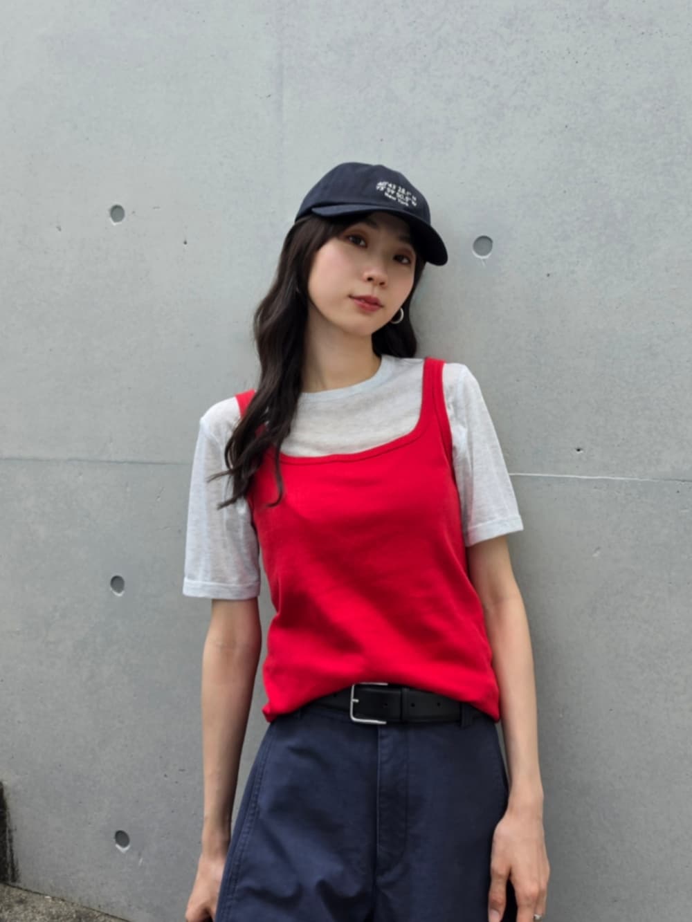 ブラック系のハンドバッグ、ブルー系のパンツ、レッド系のタンクトップを着用したレディースの春コーディネートの2枚目の写真