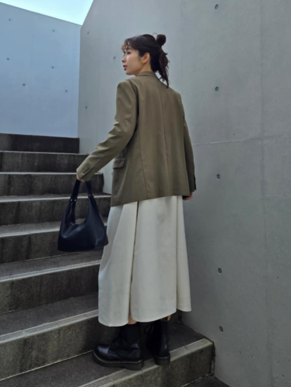 ホワイト系のワンピース、グリーン系のテーラードジャケット、ブラック系のブーツを着用したレディースの冬コーディネートの3枚目の写真
