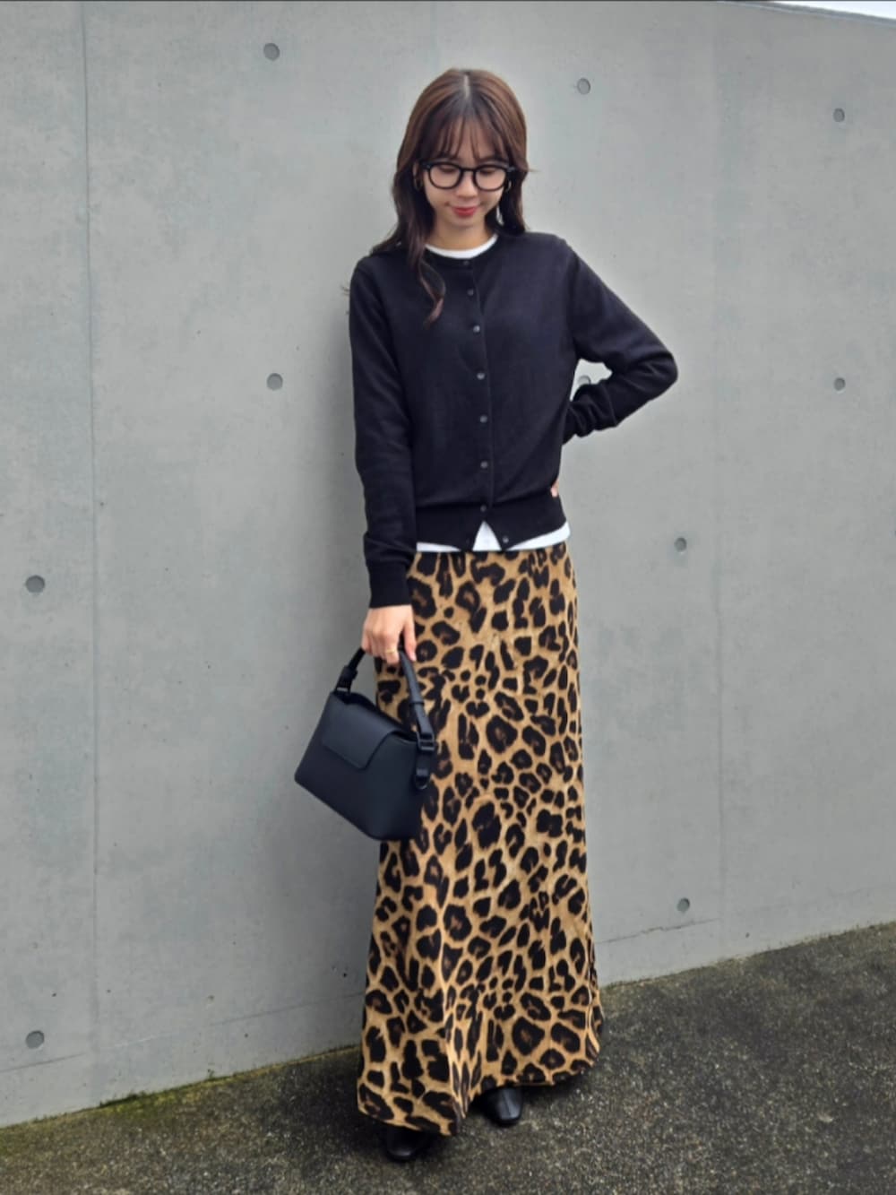 ブラック系のカーディガン/ボレロ、ブラック系のショルダーバッグ、ブラック系のブーツを着用したレディースの秋コーディネートの3枚目の写真