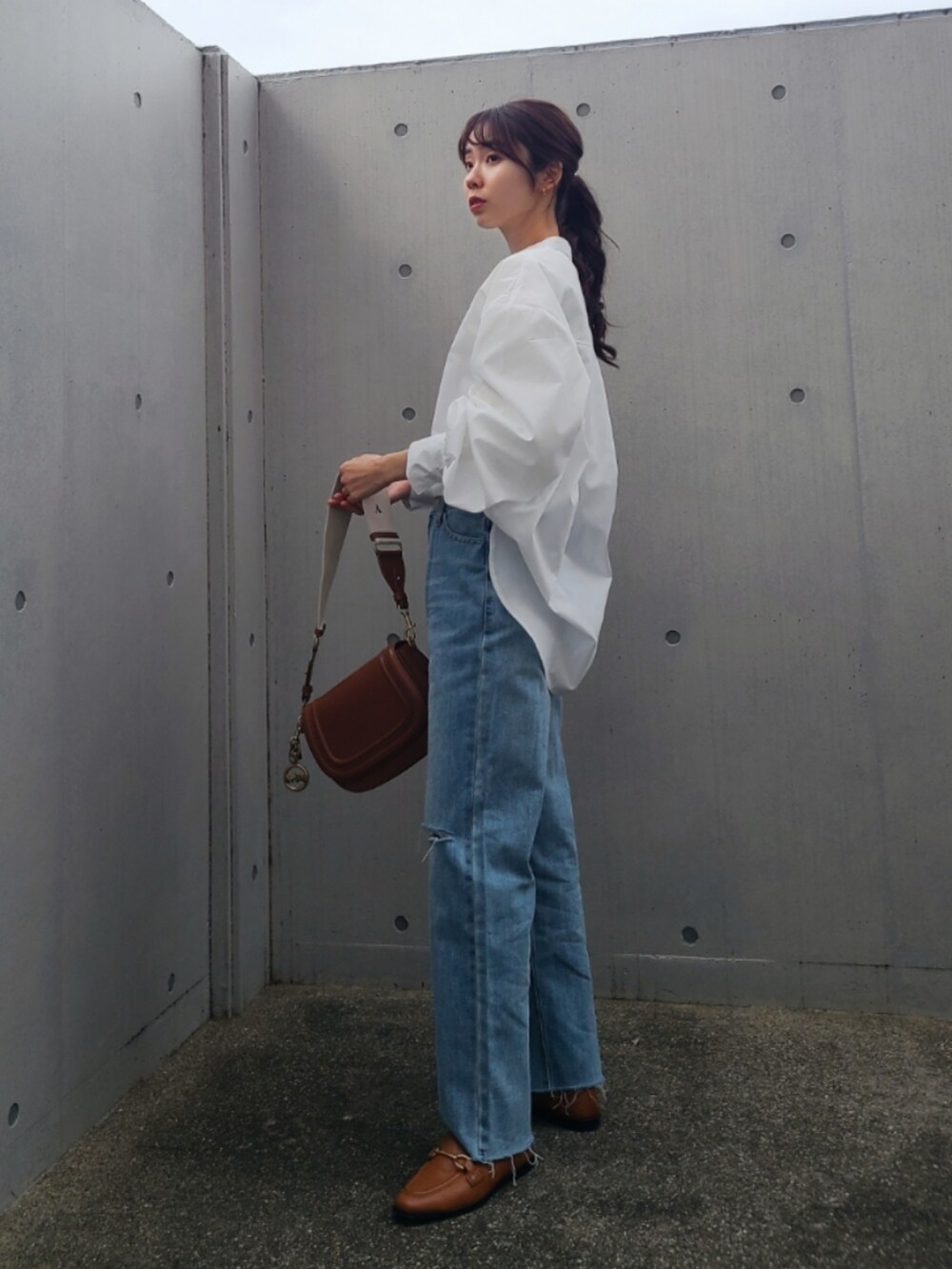 ブルー系のデニムパンツ、ブラウン系のシューズ、レッド系のパンツを着用したレディースの春コーディネートの2枚目の写真