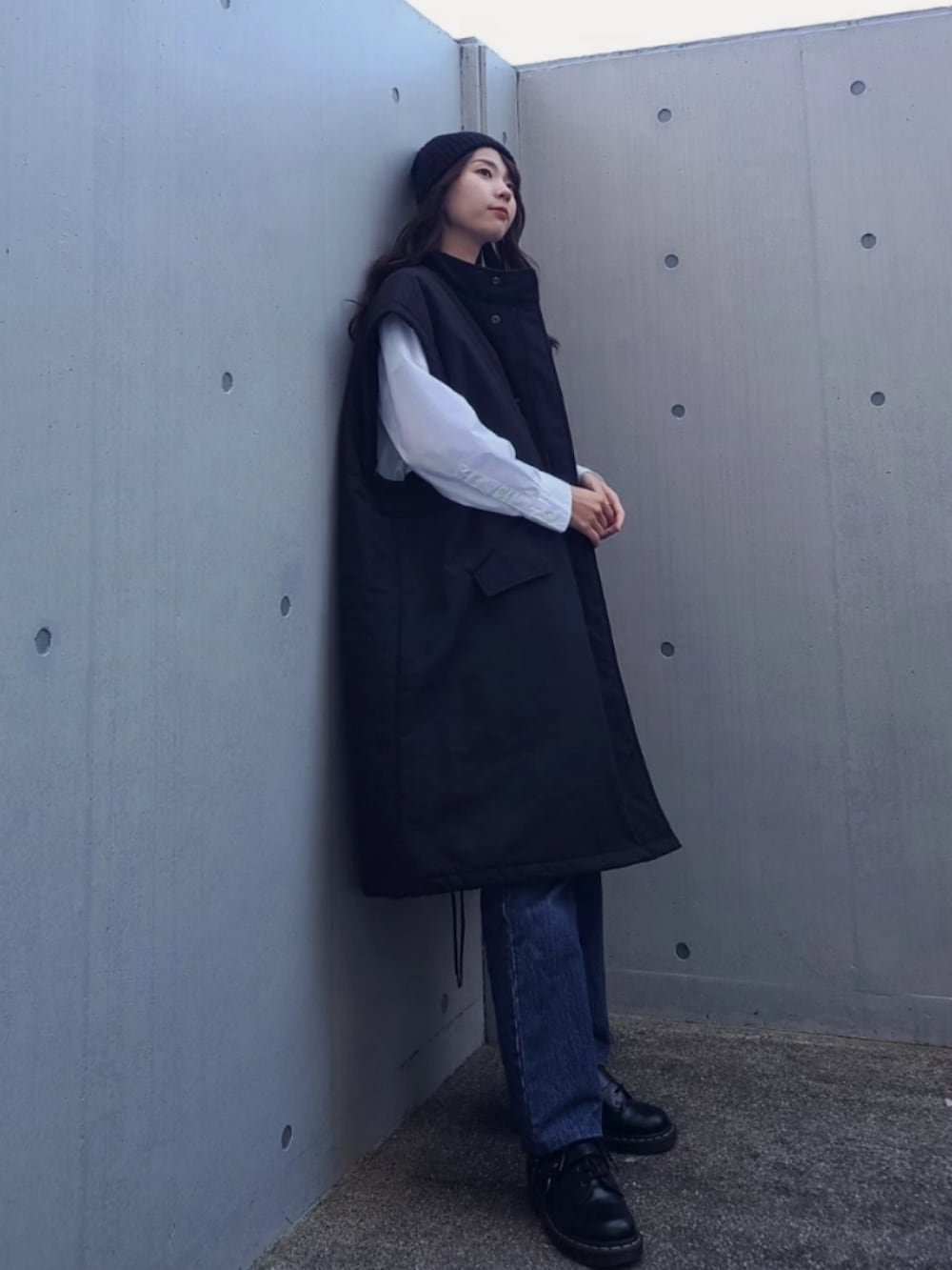 ブラック系のダウンジャケット/コート、ブルー系のデニムパンツ、ブラック系のブーツを着用したレディースの秋コーディネートの3枚目の写真