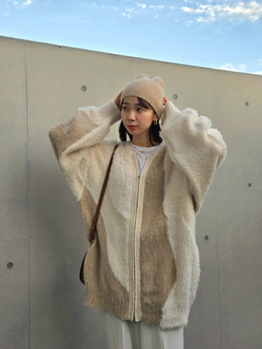 ベージュ系のカーディガン/ボレロ、ホワイト系のパンツ、ホワイト系のブーツを着用したレディースの秋コーディネートの3枚目の写真