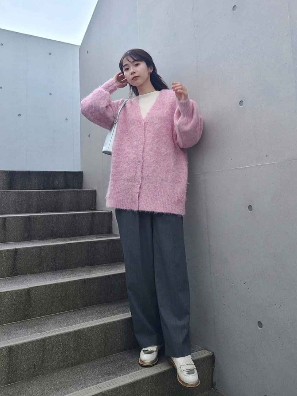 ピンク系のカーディガン/ボレロ、シルバー系のバッグ、ホワイト系のその他シューズを着用したレディースの冬コーディネートの3枚目の写真