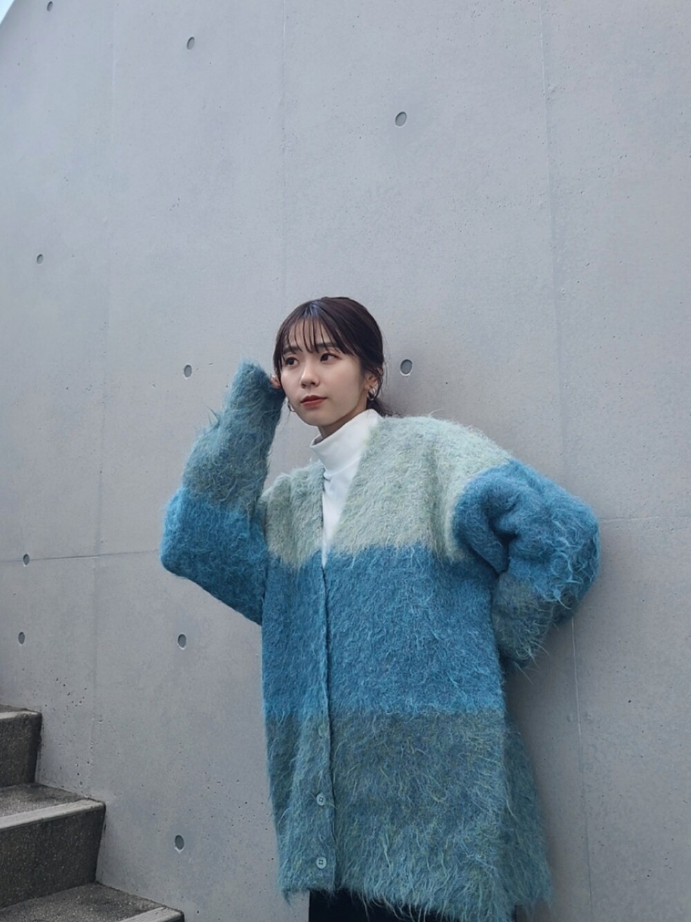 ブルー系のカーディガン/ボレロ、ブラック系のブーツを着用したレディースの冬コーディネートの4枚目の写真