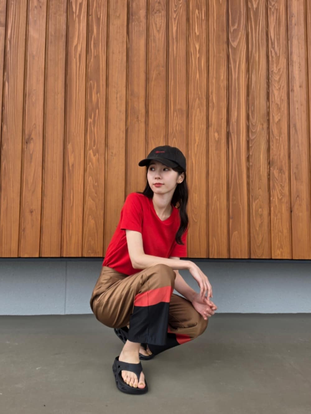 ブラウン系のその他パンツ、ブラック系のサンダル、レッド系のTシャツ/カットソーを着用したレディースの夏コーディネートの4枚目の写真