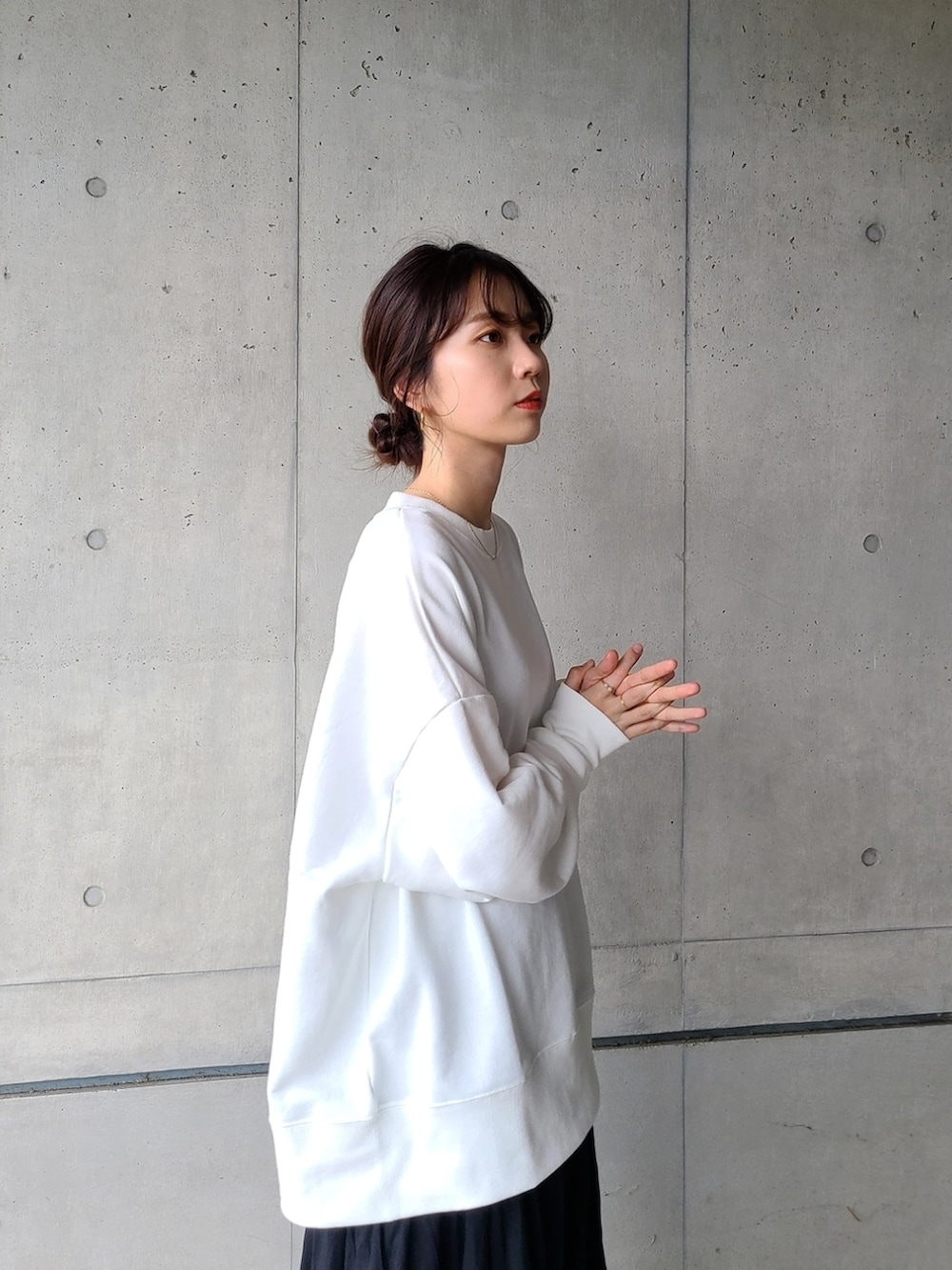 ホワイト系のスウェット、ブラック系のスカート、その他のスニーカーを着用したレディースの秋コーディネートの3枚目の写真