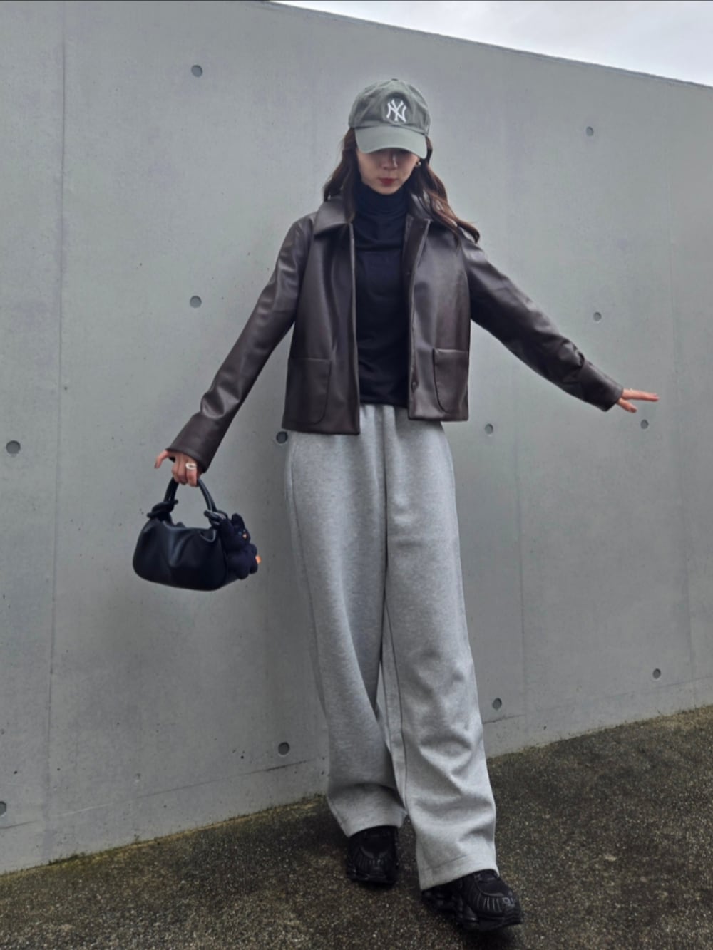 ブラック系のスニーカー、ブラック系のハンドバッグ、ブラウン系のジャケット/アウターを着用したレディースの秋コーディネートの5枚目の写真