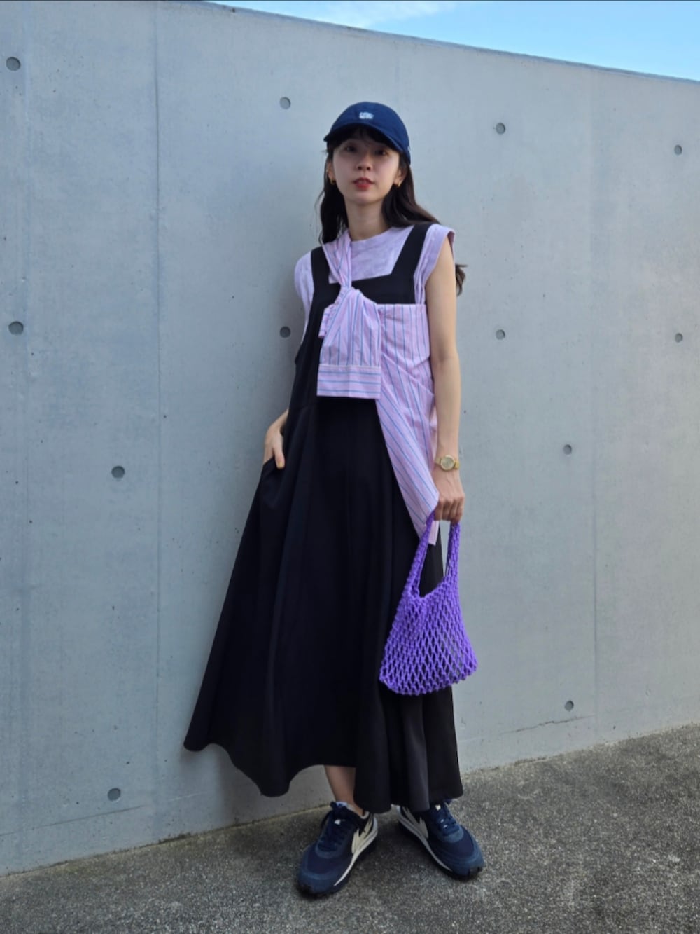 ブルー系のスニーカー、ブルー系のスニーカー、パープル系のハンドバッグを着用したレディースの秋コーディネートの3枚目の写真