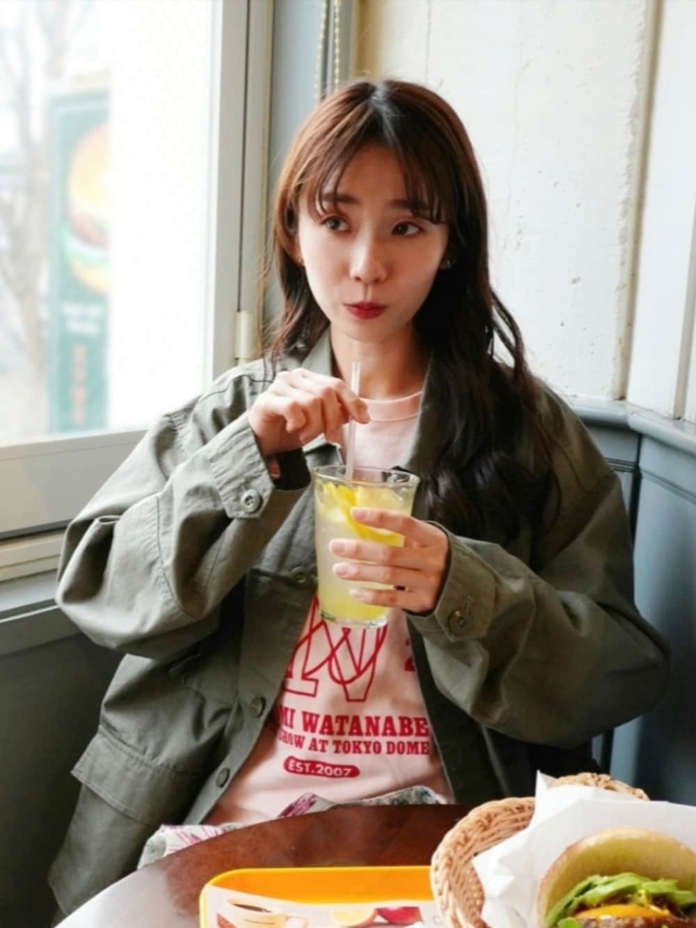 グリーン系のミリタリージャケット、ベージュ系のショルダーバッグ、ホワイト系のその他パンツを着用したレディースの春コーディネートの3枚目の写真