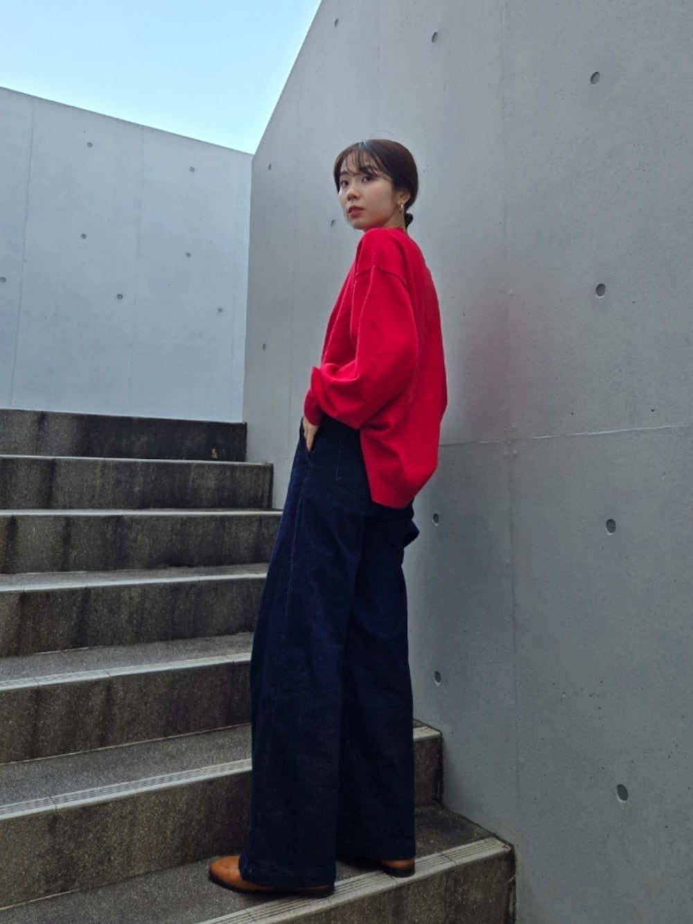 ブルー系のデニムパンツ、ブラウン系のバッグ、ブルー系のデニムジャケットを着用したレディースの秋コーディネートの2枚目の写真