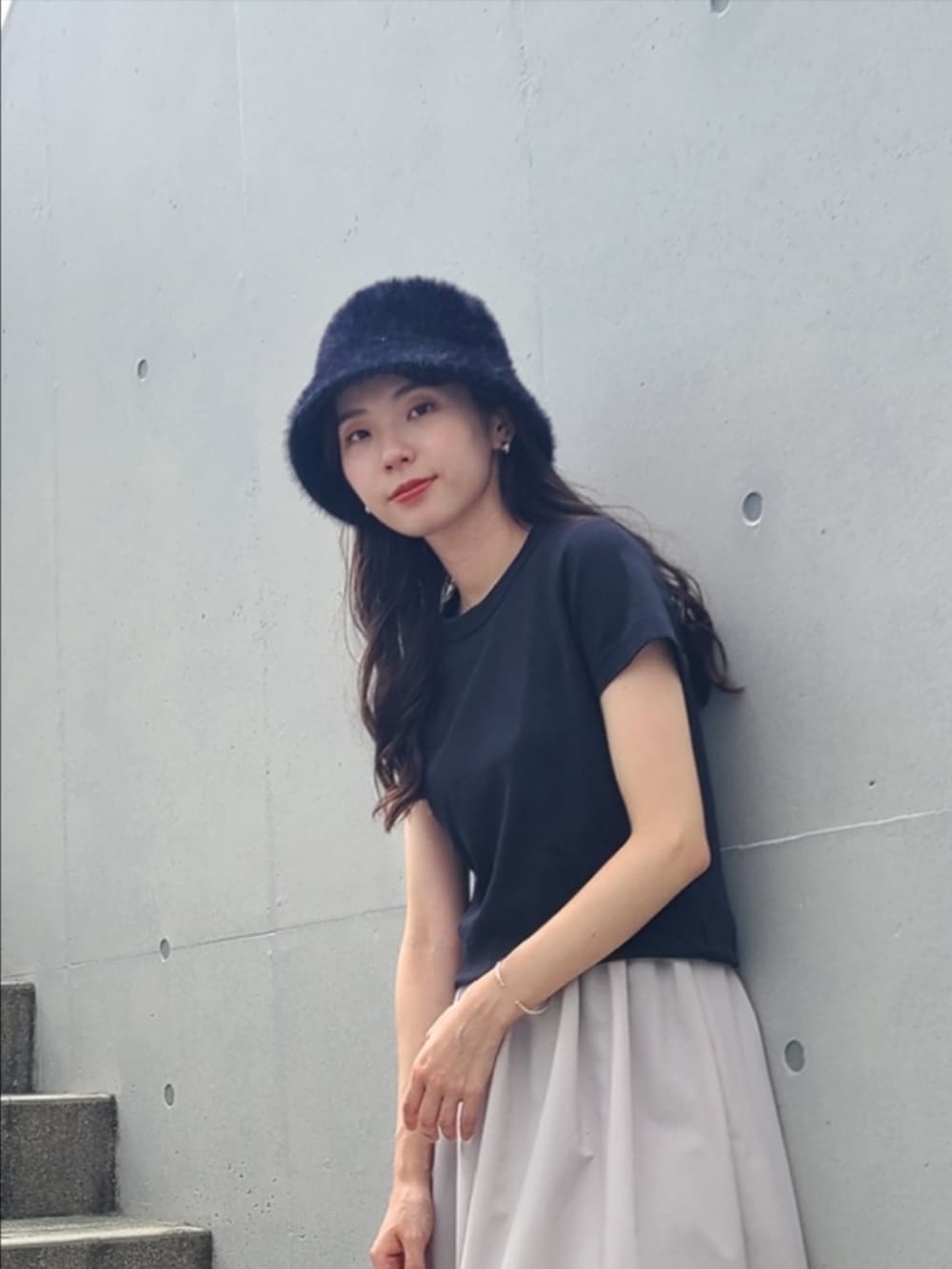 グレー系のスカート、ブラック系のTシャツ/カットソー、オレンジ系のスニーカーを着用したレディースの秋コーディネートの2枚目の写真