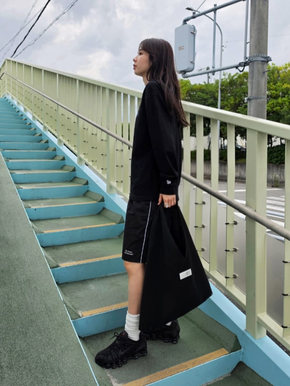 ブラック系のTシャツ/カットソー、ブラック系のハンドバッグ、ブラック系のパンツを着用したレディースの夏コーディネートの2枚目の写真