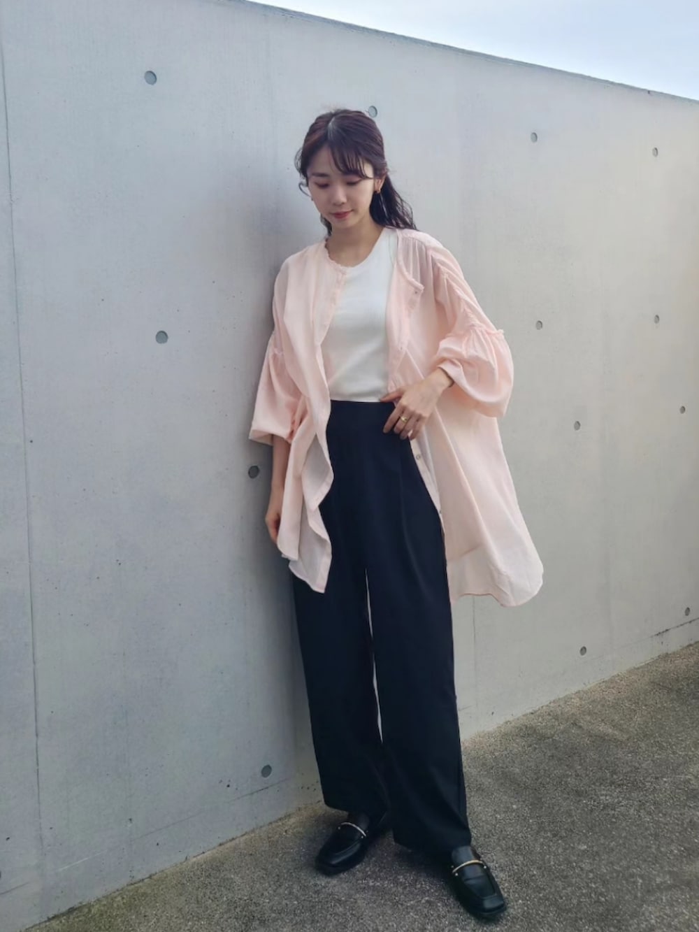 ピンク系のシャツ/ブラウス、ブラック系のパンツ、ブルー系のキャップを着用したレディースの春コーディネートの2枚目の写真