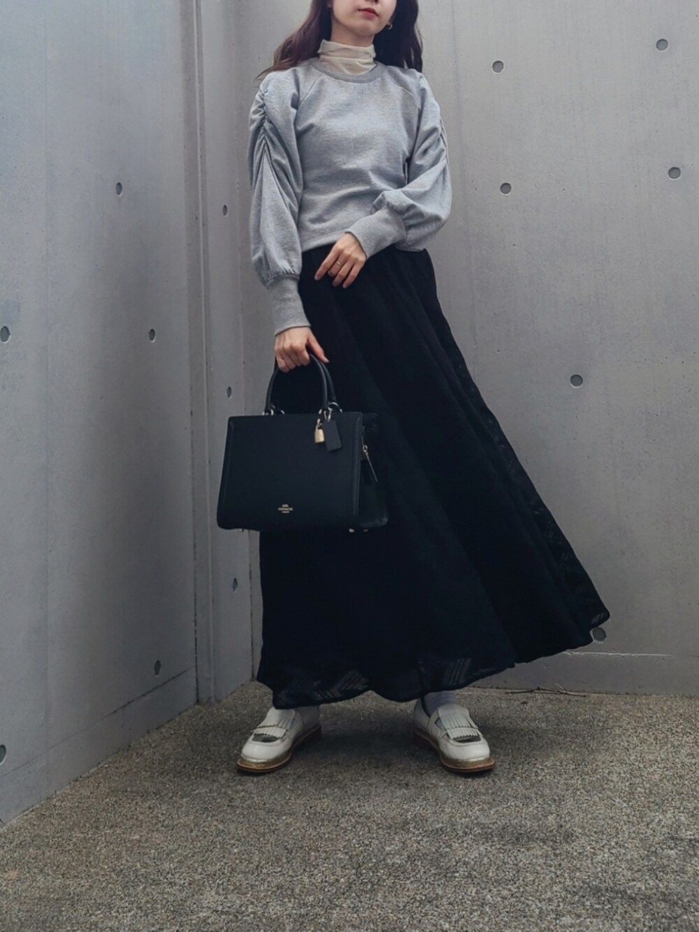 ブラック系のスカート、グレー系のTシャツ/カットソー、ホワイト系のその他シューズを着用したレディースの冬コーディネートの2枚目の写真