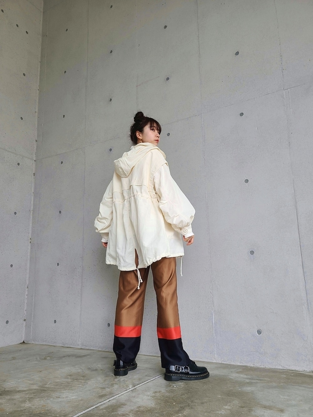 ブラウン系のその他パンツ、ブラック系のブーツ、ゴールド系のピアス（両耳用）を着用したレディースの春コーディネートの2枚目の写真