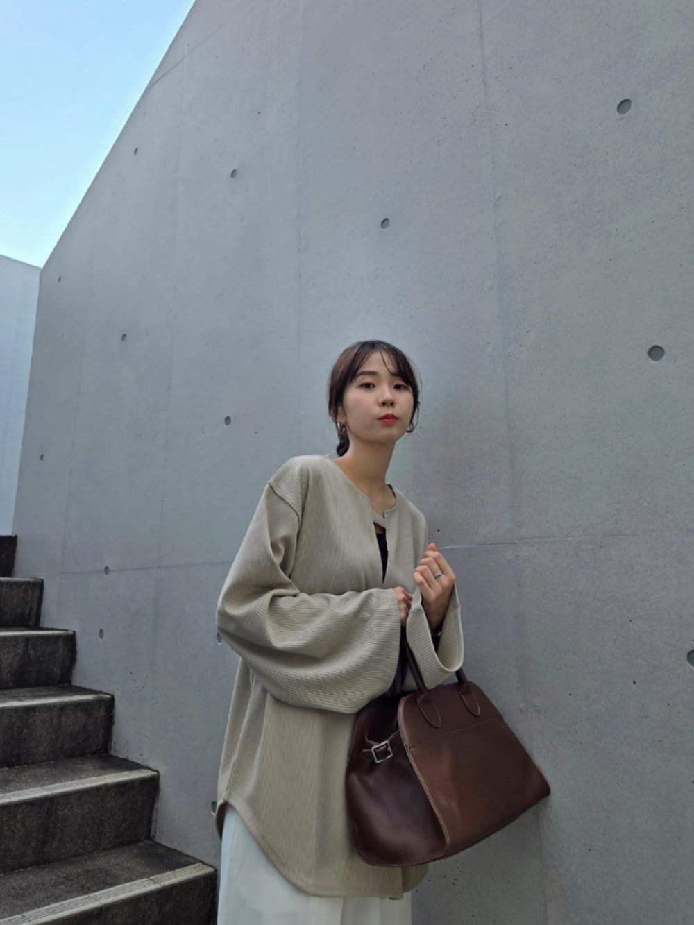 ベージュ系のTシャツ/カットソー、ホワイト系のパンツ、ブラック系のブーツを着用したレディースの秋コーディネートの3枚目の写真