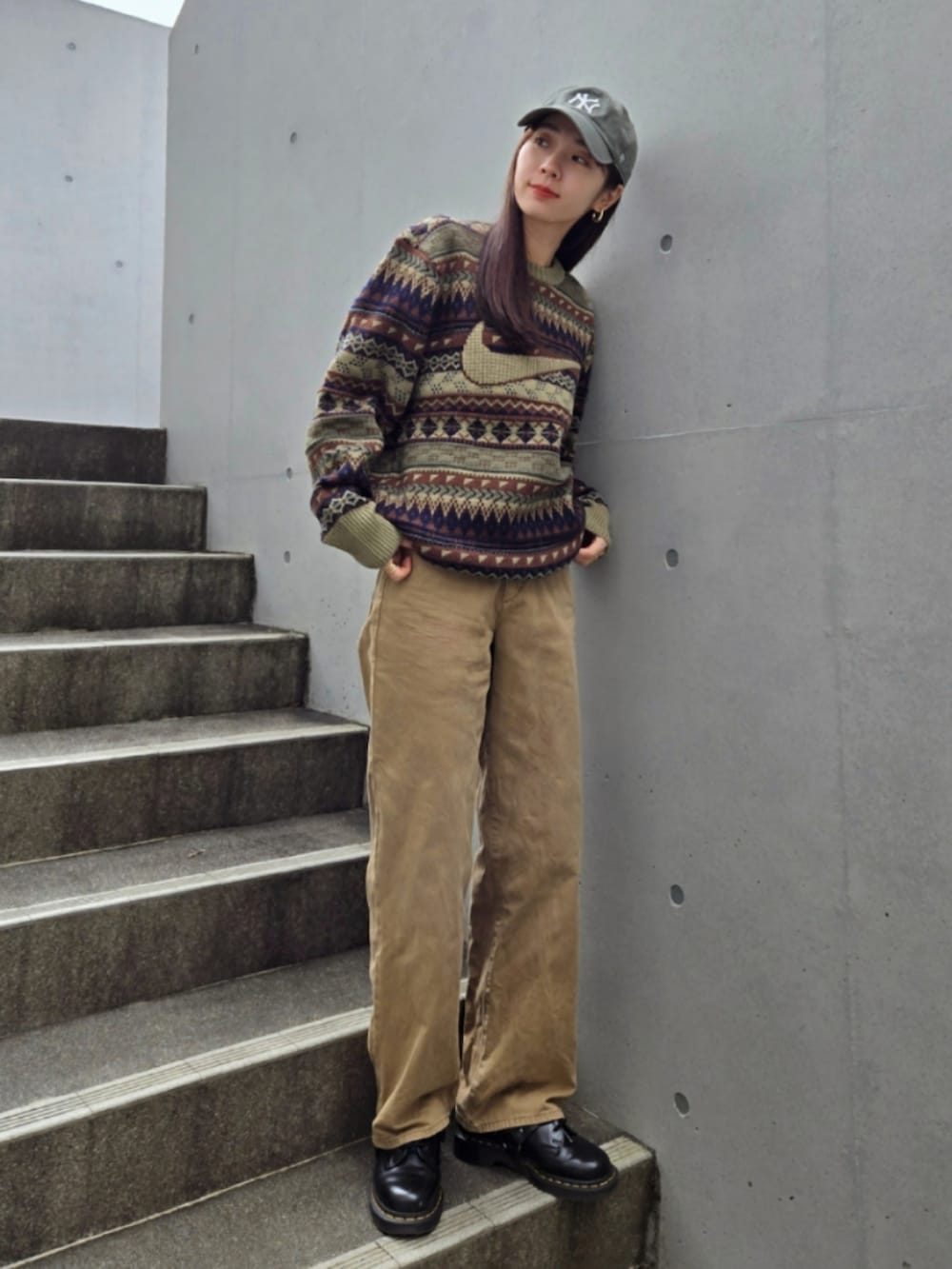 グリーン系のニット/セーター、レッド系のハンドバッグ、グリーン系のデニムパンツを着用したレディースの冬コーディネートの2枚目の写真