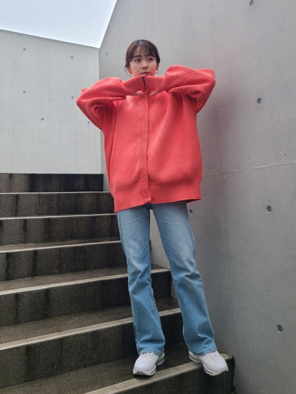 ブルー系のデニムパンツ、ホワイト系のスニーカー、ピンク系のカーディガン/ボレロを着用したレディースの冬コーディネートの2枚目の写真