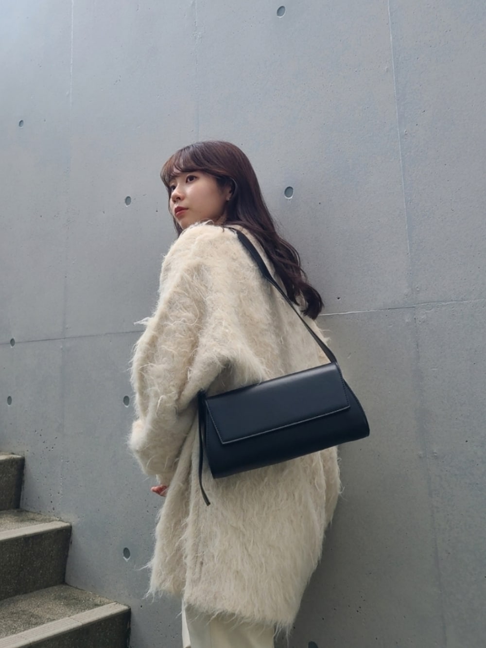 ホワイト系のパンツ、ホワイト系のカーディガン/ボレロ、ブラック系のショルダーバッグを着用したレディースの秋コーディネートの3枚目の写真