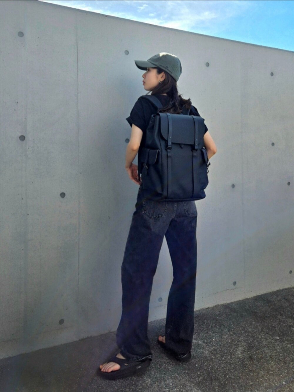 ブラック系のサンダル、ブラック系のTシャツ/カットソー、ブラック系のバックパック/リュックを着用したレディースの夏コーディネートの2枚目の写真