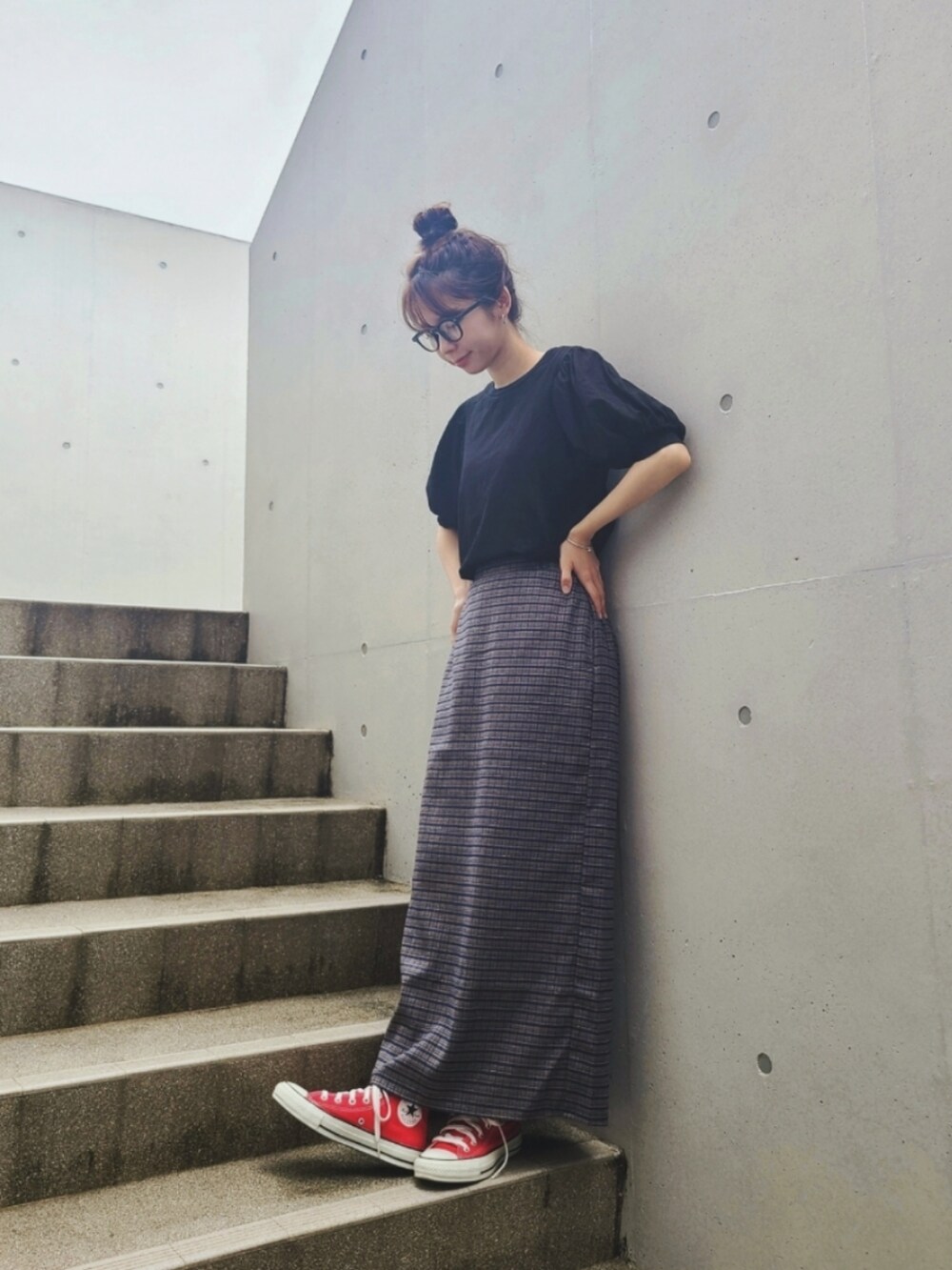 ブラック系のTシャツ/カットソー、ブルー系のスカート、レッド系のスニーカーを着用したレディースの夏コーディネートの3枚目の写真