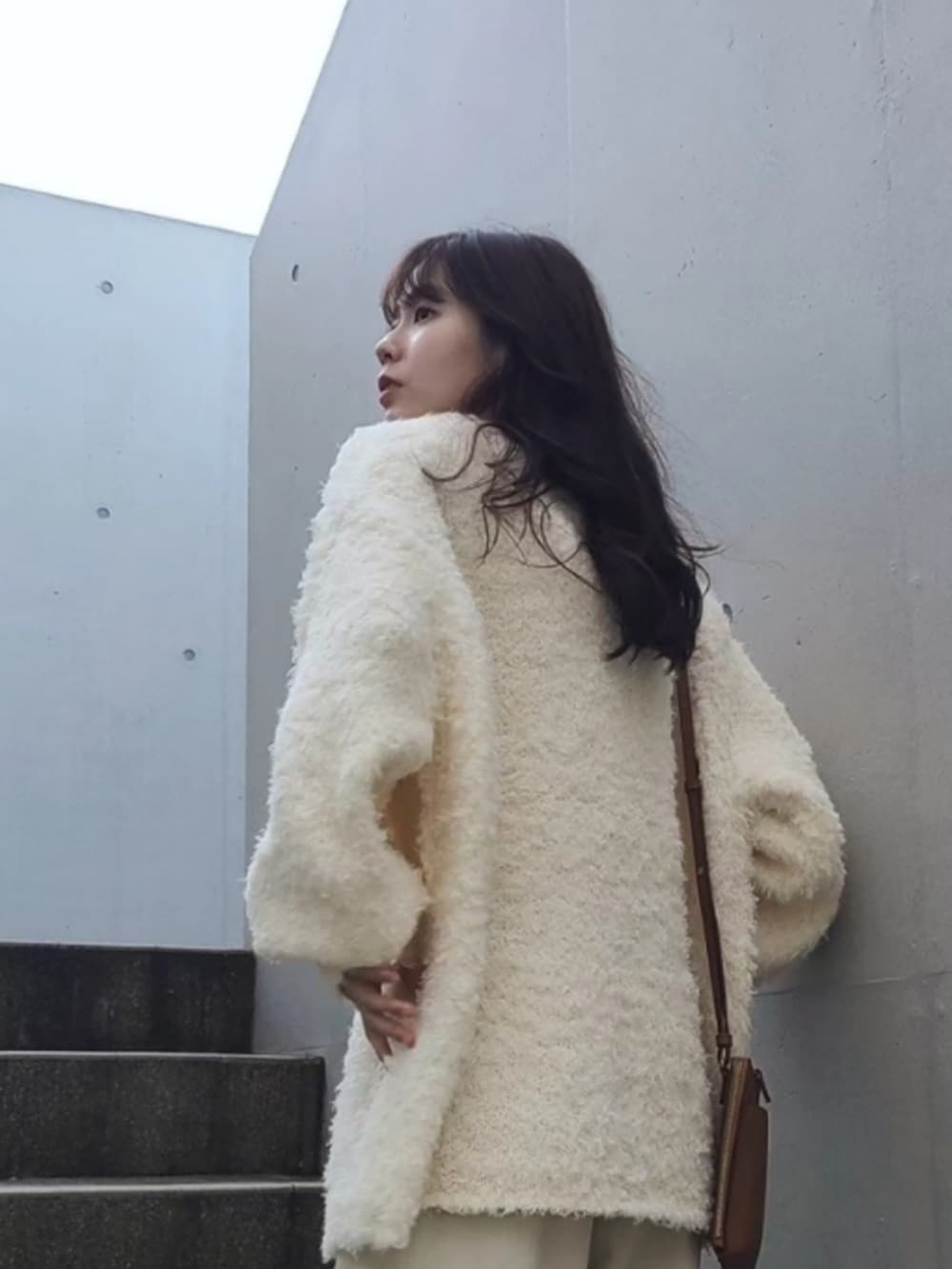 ホワイト系のニット/セーター、ブラウン系のシューズ、ゴールド系のピアス（両耳用）を着用したレディースの秋コーディネートの2枚目の写真