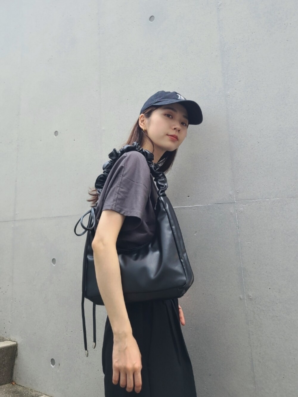 ブラック系のその他パンツ、ブラック系のショルダーバッグ、グレー系のトップスを着用したレディースの春コーディネートの3枚目の写真