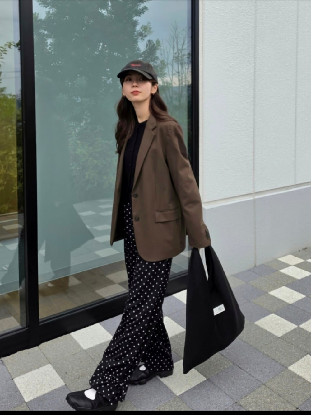 ブラック系のスウェットパンツ、ブラック系のスニーカー、ブラック系のハンドバッグを着用したレディースの秋コーディネートの3枚目の写真