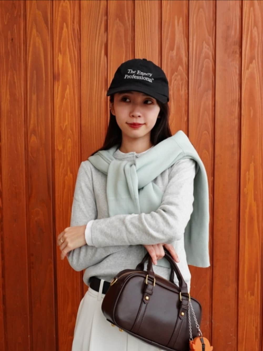 グレー系のパーカー、ホワイト系のパンツ、ホワイト系のスニーカーを着用したレディースの春コーディネートの2枚目の写真