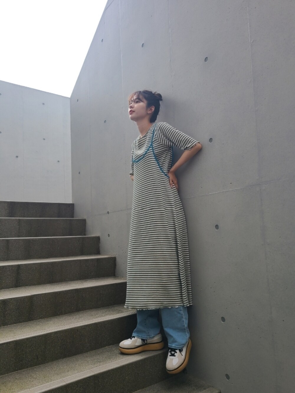 グリーン系のワンピース、グリーン系のTシャツ/カットソー、ホワイト系のスニーカーを着用したレディースの夏コーディネートの3枚目の写真