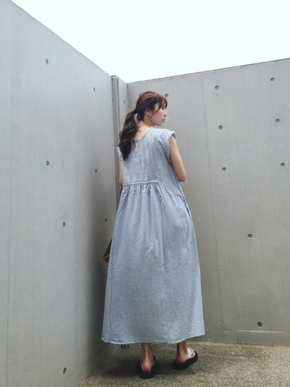 ブルー系のワンピース、ホワイト系のサンダル、グリーン系のトートバッグを着用したレディースの夏コーディネートの4枚目の写真