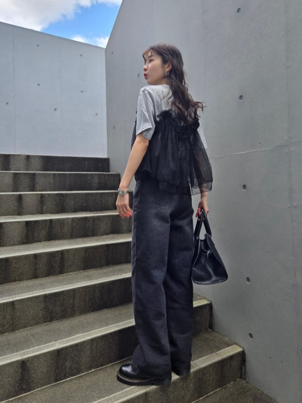 グレー系のTシャツ/カットソー、ブラック系のボストンバッグ、ブラック系のブーツを着用したレディースの春コーディネートの4枚目の写真