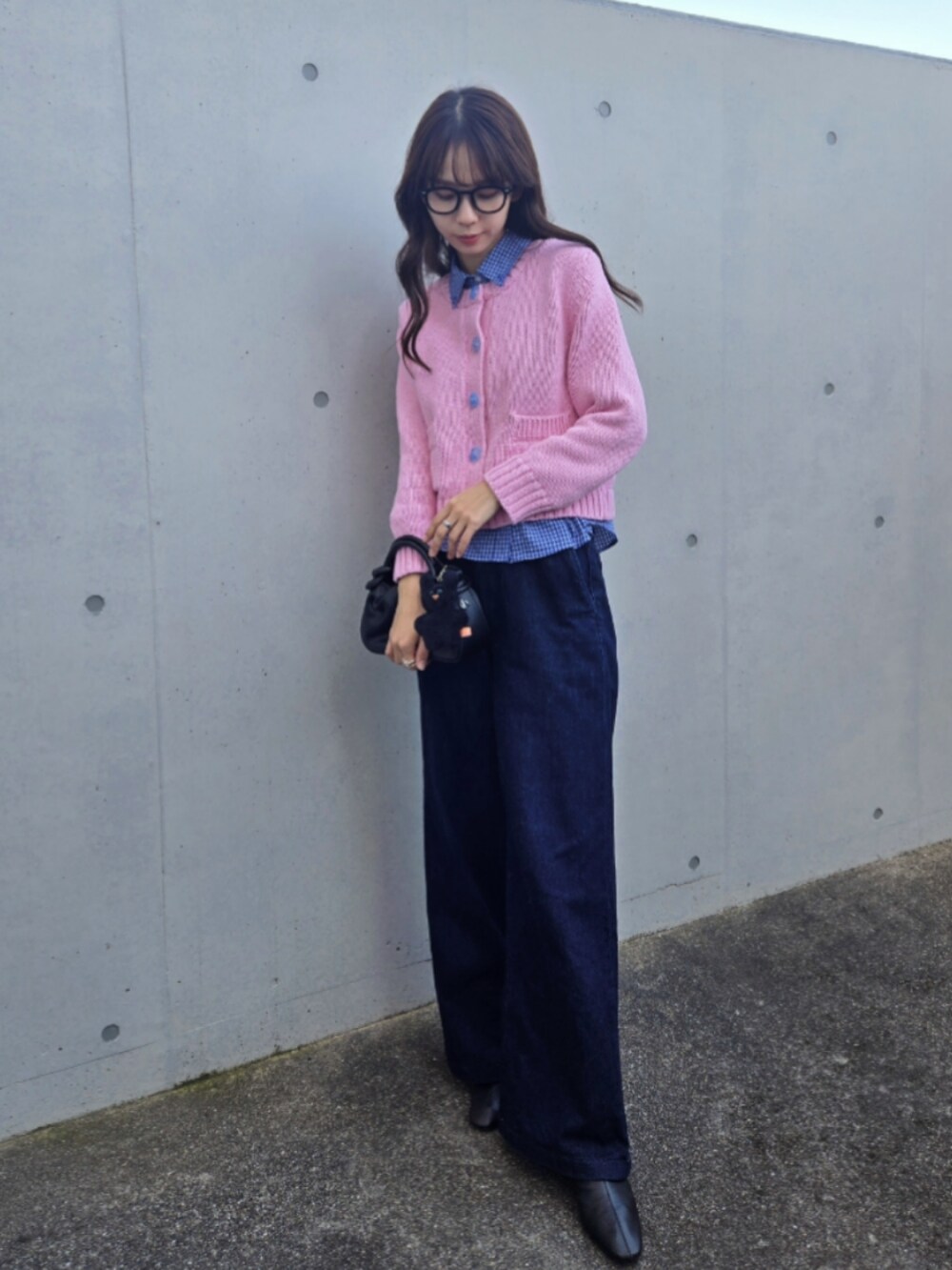 ピンク系のカーディガン/ボレロ、ブルー系のシャツ/ブラウス、ブラック系のハンドバッグを着用したレディースの秋コーディネートの3枚目の写真