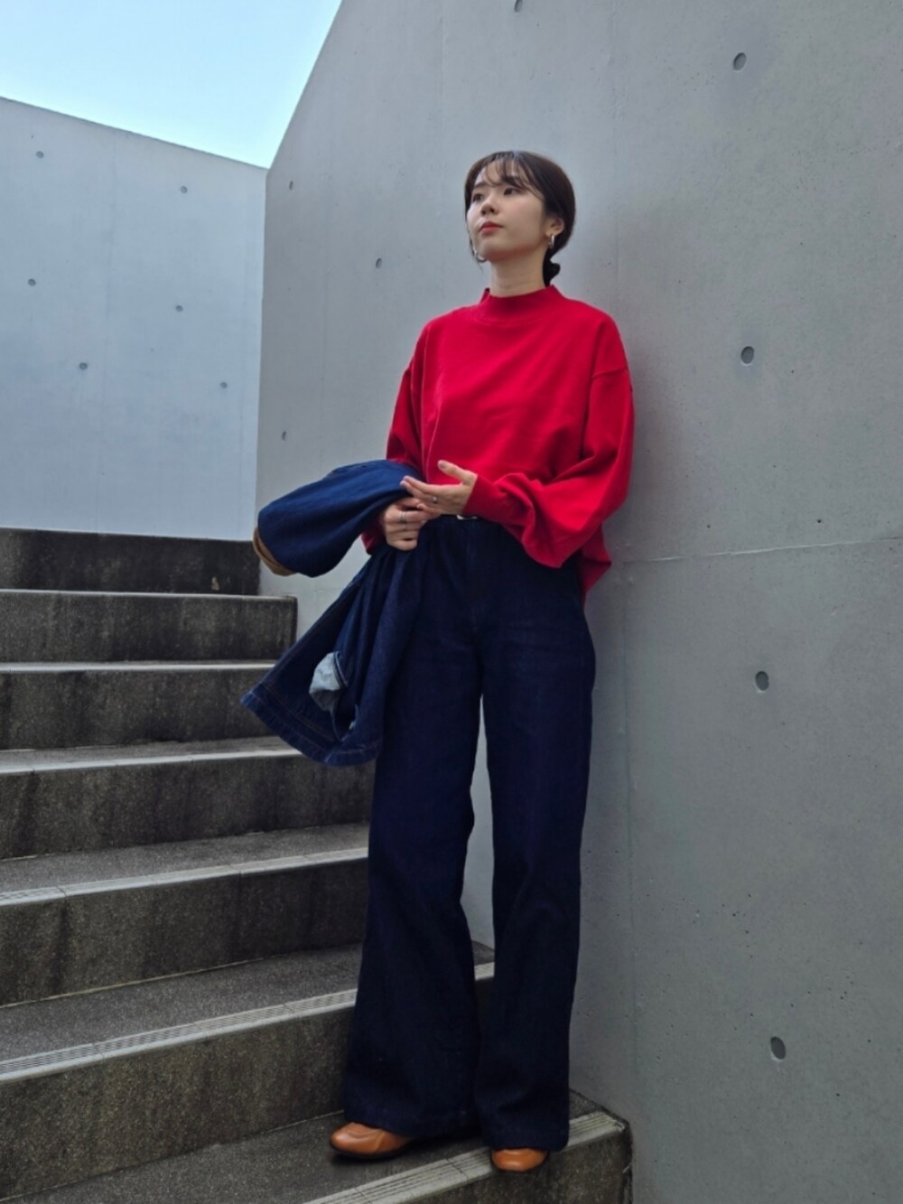 ブルー系のデニムパンツ、ブラウン系のバッグ、ブルー系のデニムジャケットを着用したレディースの秋コーディネートの5枚目の写真