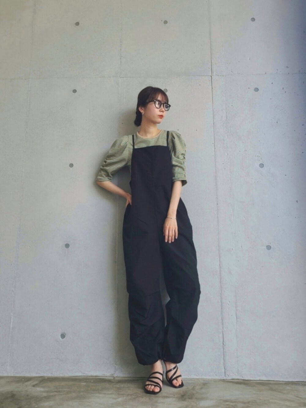 ブラック系のサロペット/オーバーオール、グリーン系のTシャツ/カットソーを着用したレディースの春コーディネートの3枚目の写真