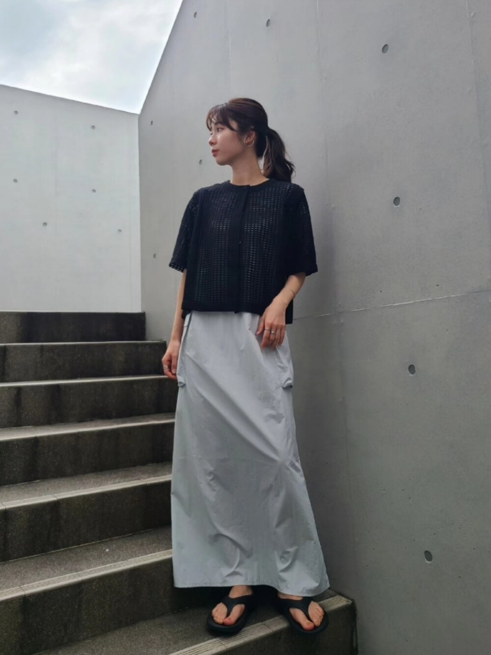 ブラック系のサンダル、ブラック系のカーディガン/ボレロ、グレー系のワンピースを着用したレディースの夏コーディネートの4枚目の写真