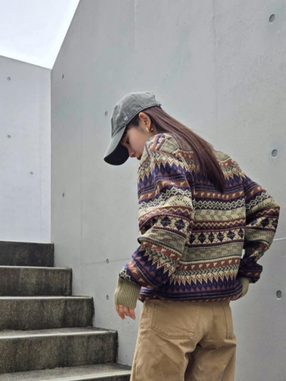 グリーン系のニット/セーター、レッド系のハンドバッグ、グリーン系のデニムパンツを着用したレディースの冬コーディネートの3枚目の写真