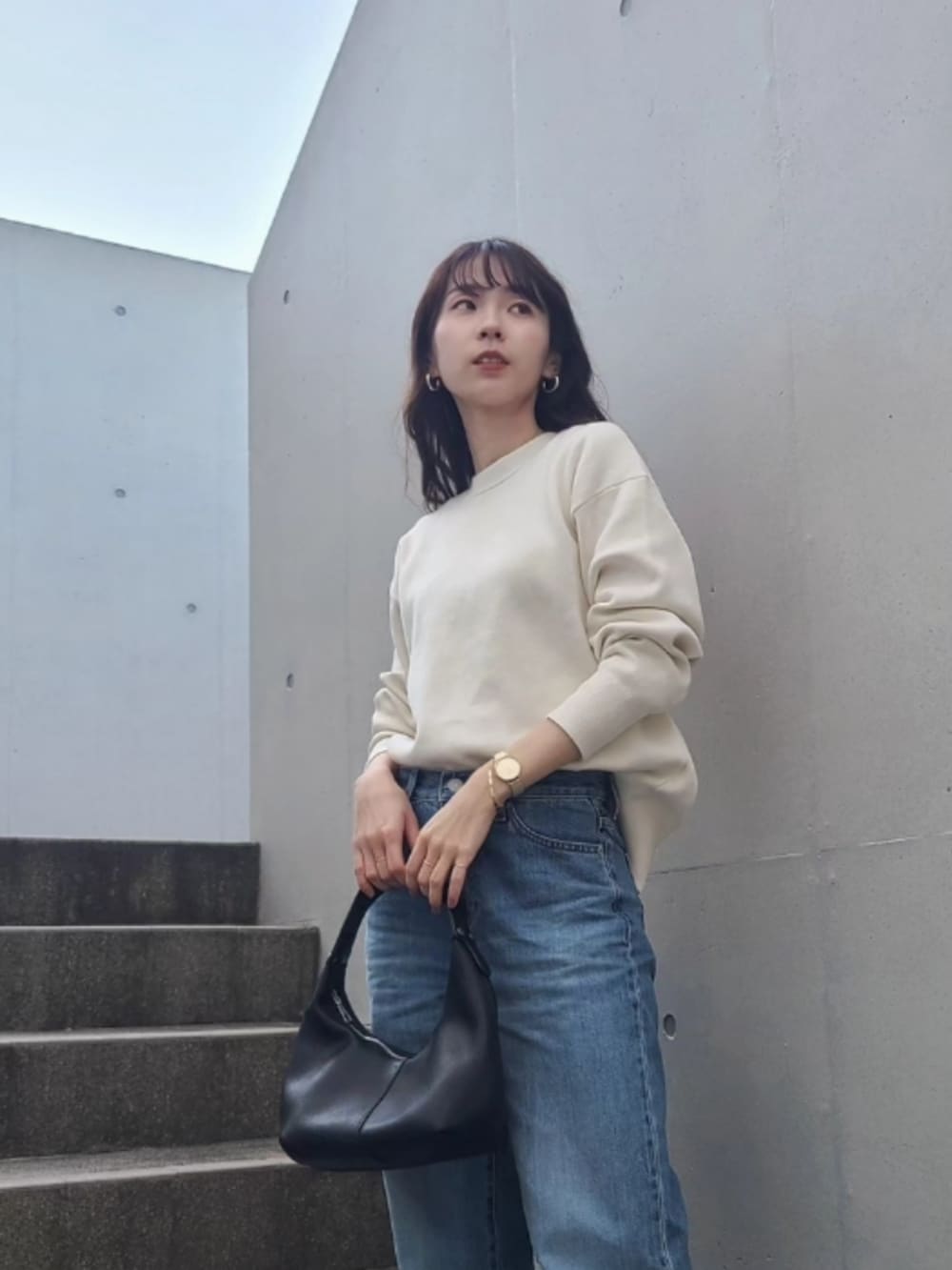 ホワイト系のダウンジャケット/コート、ブラック系のブーツ、ブラック系のハンドバッグを着用したレディースの冬コーディネートの3枚目の写真