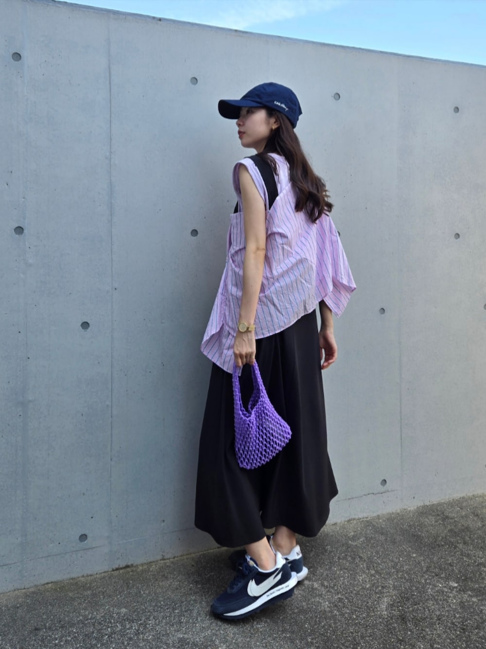 ブルー系のスニーカー、ブルー系のスニーカー、パープル系のハンドバッグを着用したレディースの秋コーディネートの2枚目の写真