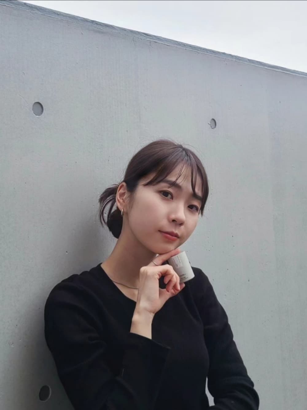 ブラック系のナイロンジャケット、ホワイト系のパンツ、ブラック系のブーツを着用したレディースの春コーディネートの5枚目の写真