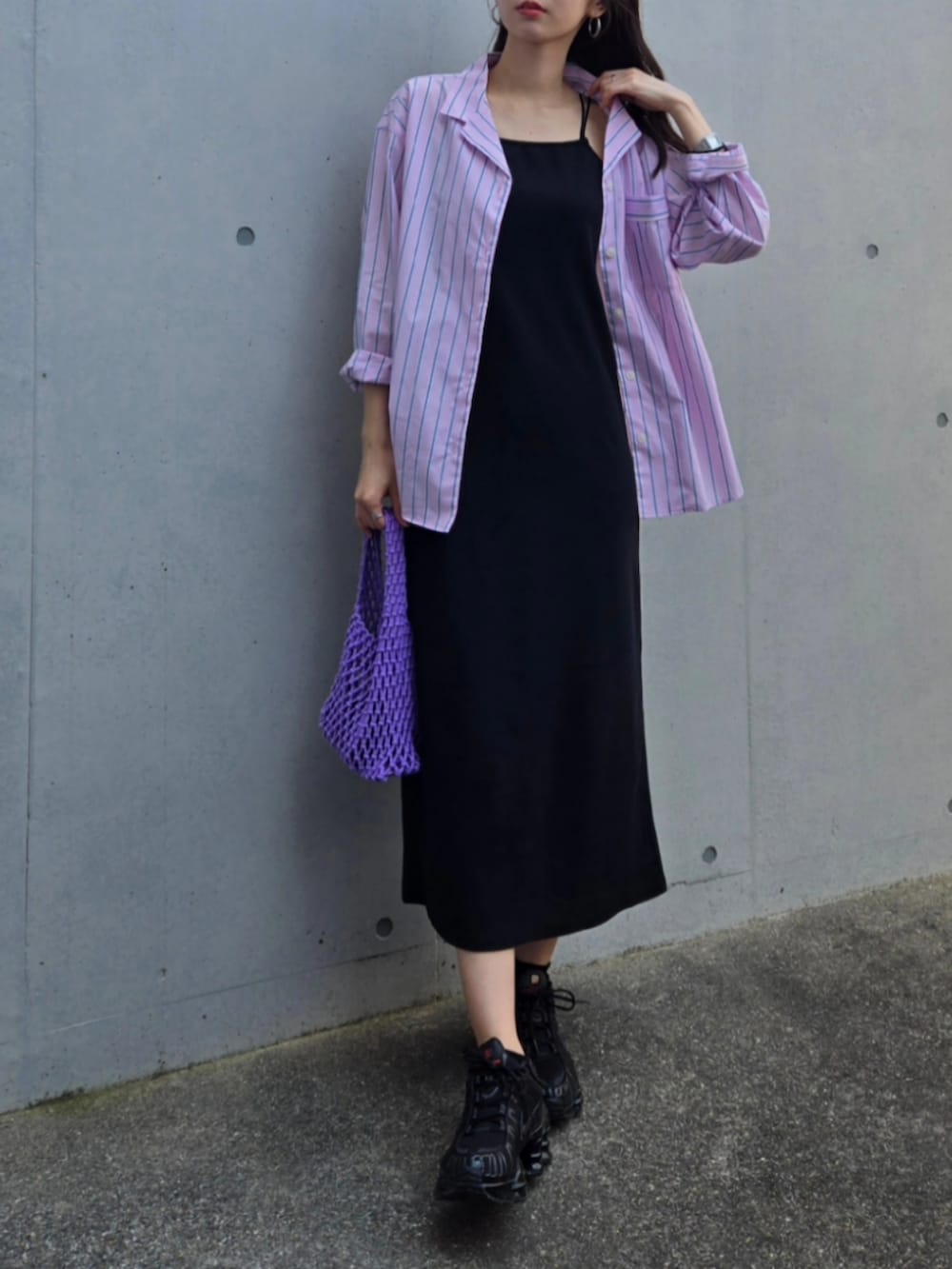 ブラック系のスニーカー、パープル系のハンドバッグ、ピンク系のシャツ/ブラウスを着用したレディースの春コーディネートの2枚目の写真