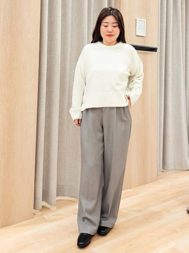グレー系のステンカラーコート、ホワイト系のニット/セーター、グレー系のその他パンツを着用したレディースの秋コーディネートの7枚目の写真