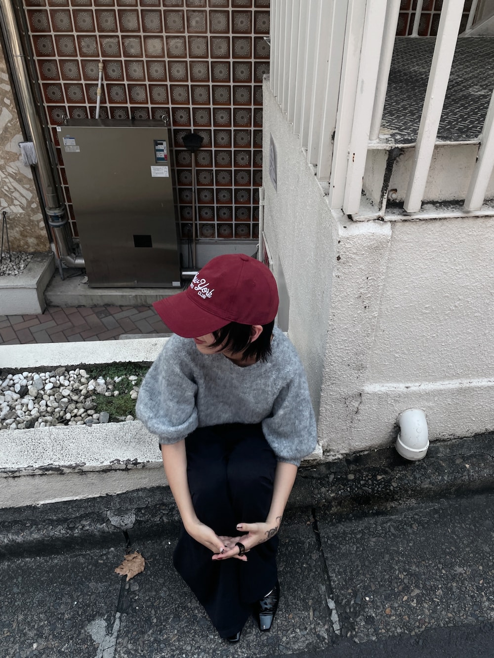 グレー系のニット/セーター、ブラック系のその他パンツ、ブラック系のベルトを着用したレディースの夏コーディネートの2枚目の写真