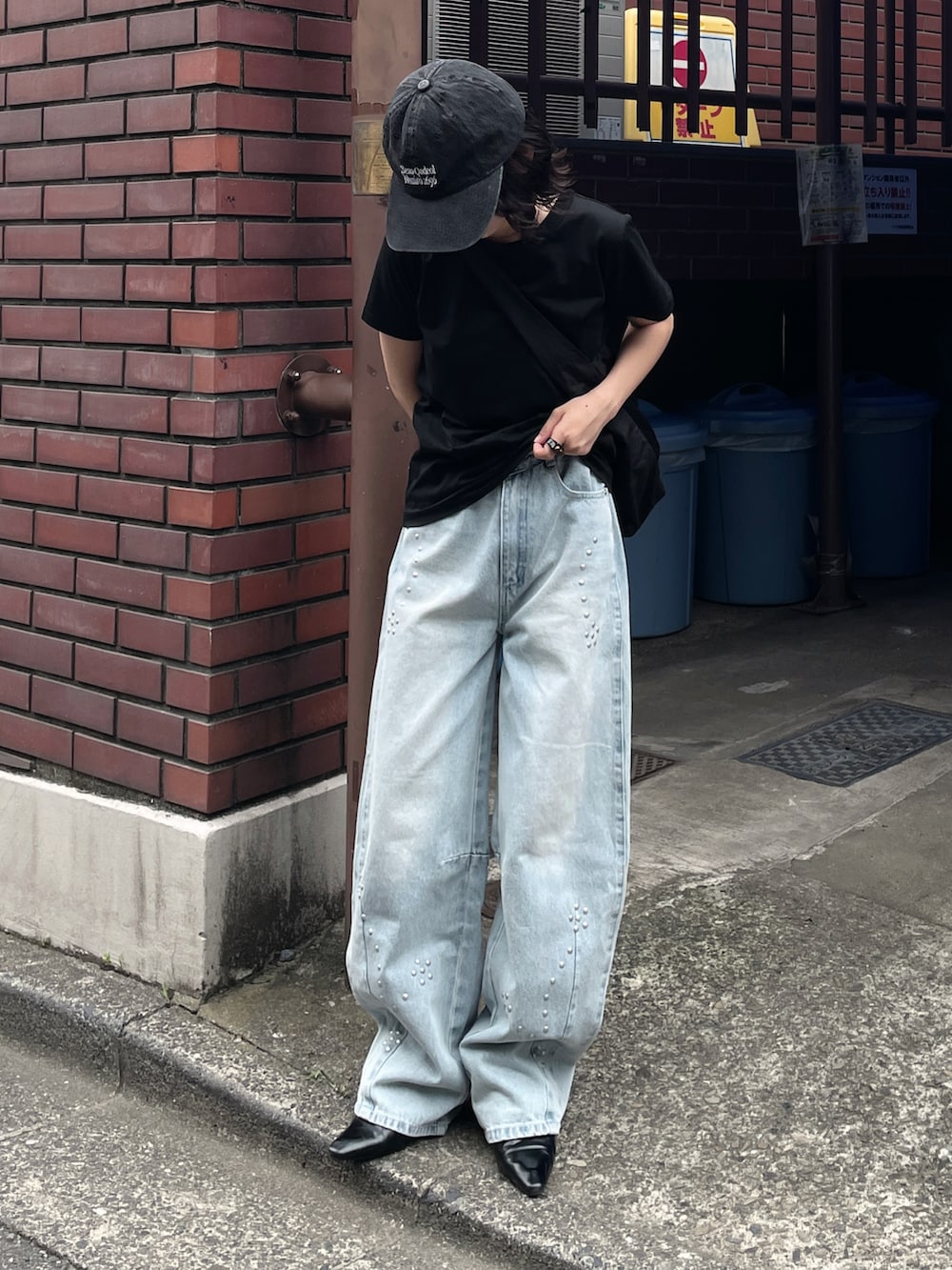 ブラック系のTシャツ/カットソー、ブルー系のデニムパンツ、ブラック系のキャップを着用したレディースの夏コーディネートの2枚目の写真