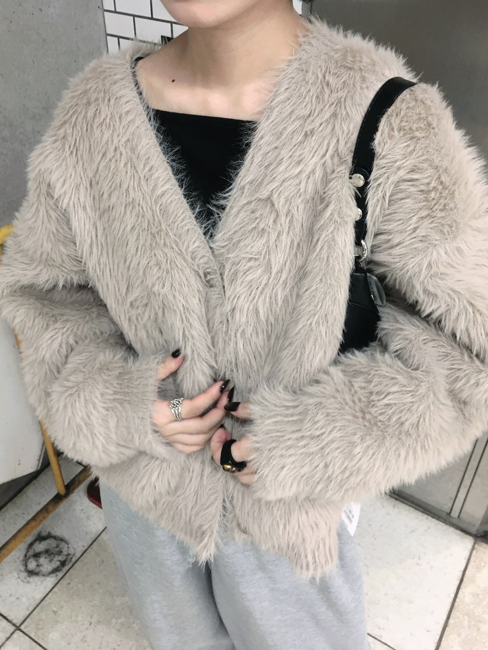 ブラウン系のカーディガン/ボレロ、グレー系のその他パンツ、ブラック系のニット/セーターを着用したレディースの秋コーディネートの2枚目の写真