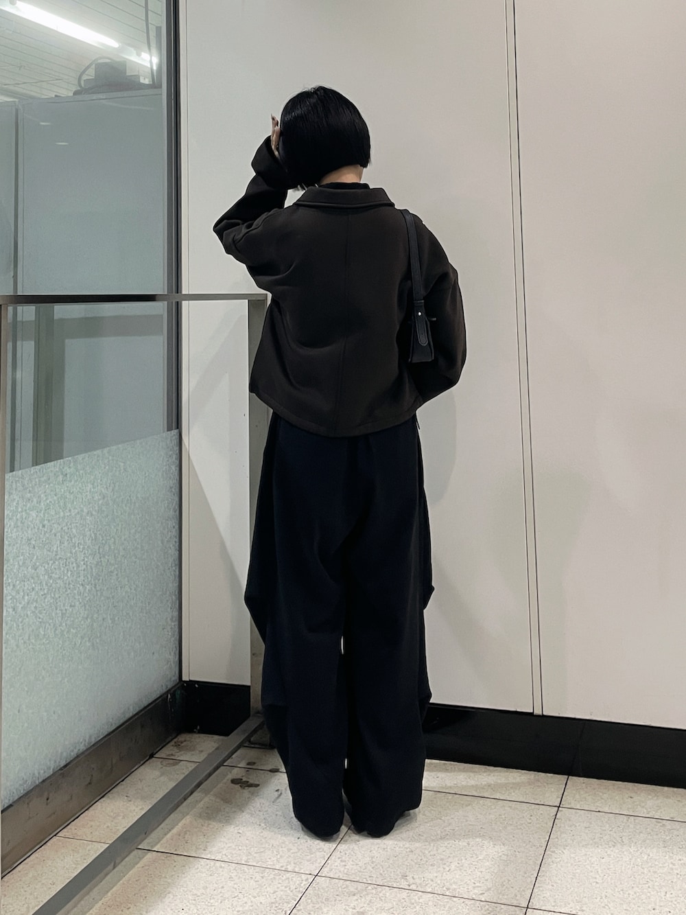 ブラウン系のブルゾン、ブラック系のその他パンツ、ブルー系のマフラーを着用したレディースの秋コーディネートの4枚目の写真