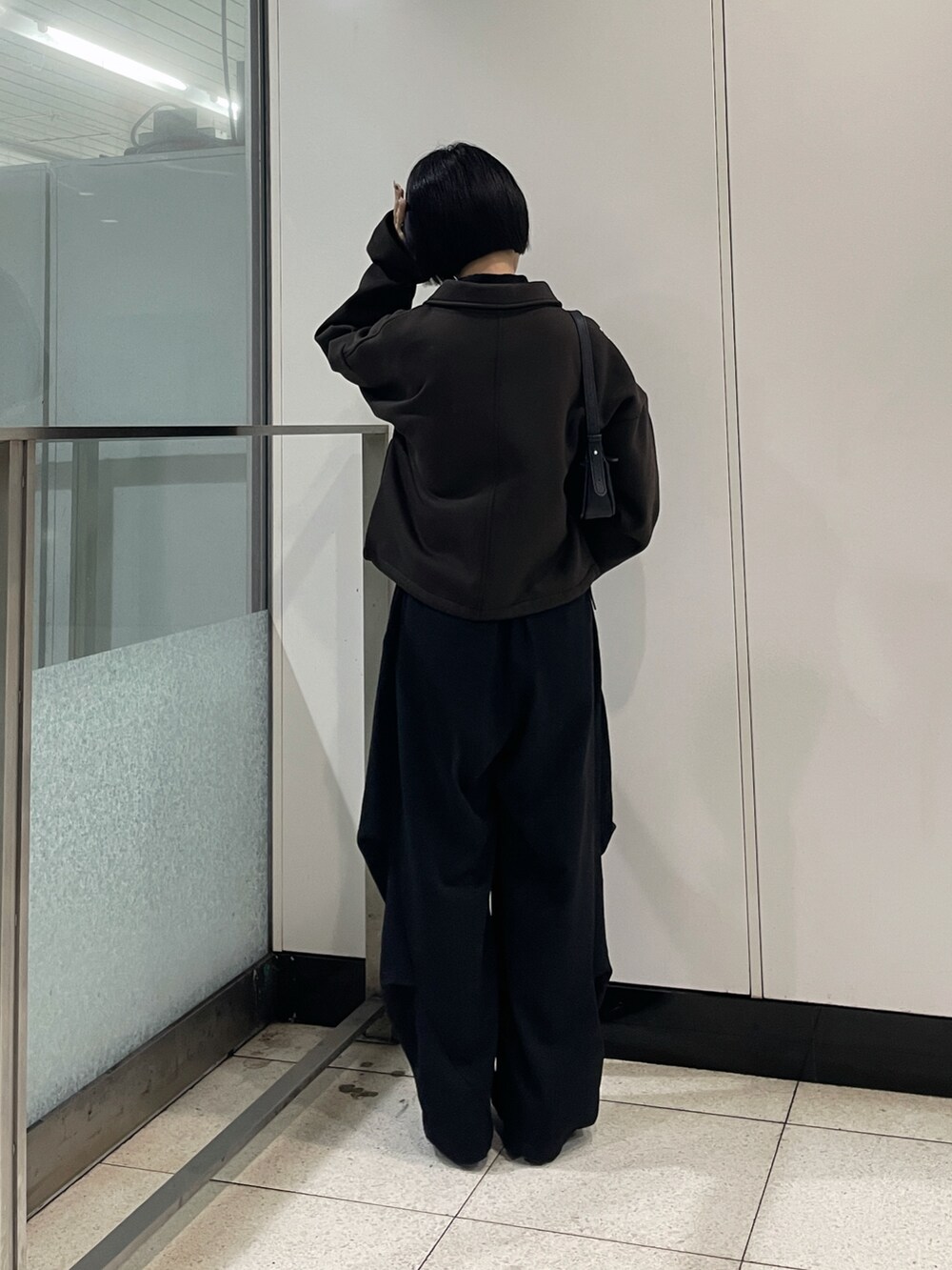 ブラウン系のブルゾン、ブラック系のその他パンツ、ブルー系のマフラーを着用したレディースの秋コーディネートの2枚目の写真