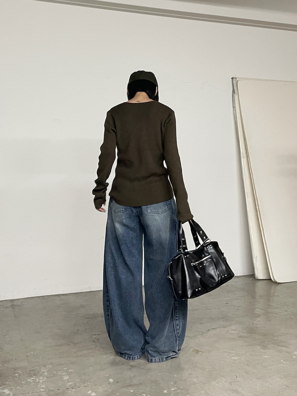 ブラウン系のカーディガン/ボレロ、ブルー系のデニムパンツ、ブラック系のトートバッグを着用したレディースの秋コーディネートの3枚目の写真