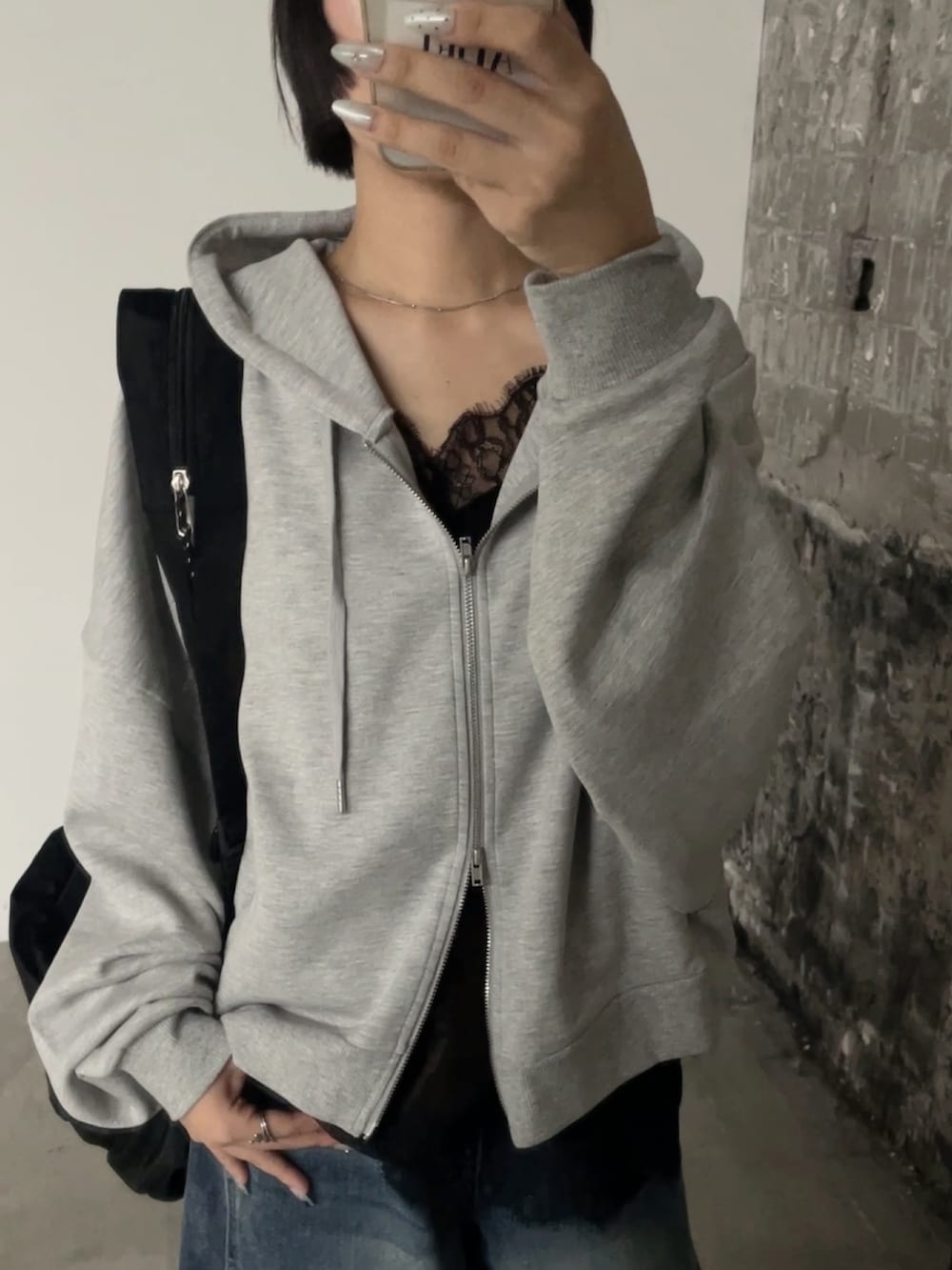 ブラウン系のタンクトップ、グレー系のTシャツ/カットソー、ブルー系のデニムパンツを着用したレディースの秋コーディネートの2枚目の写真