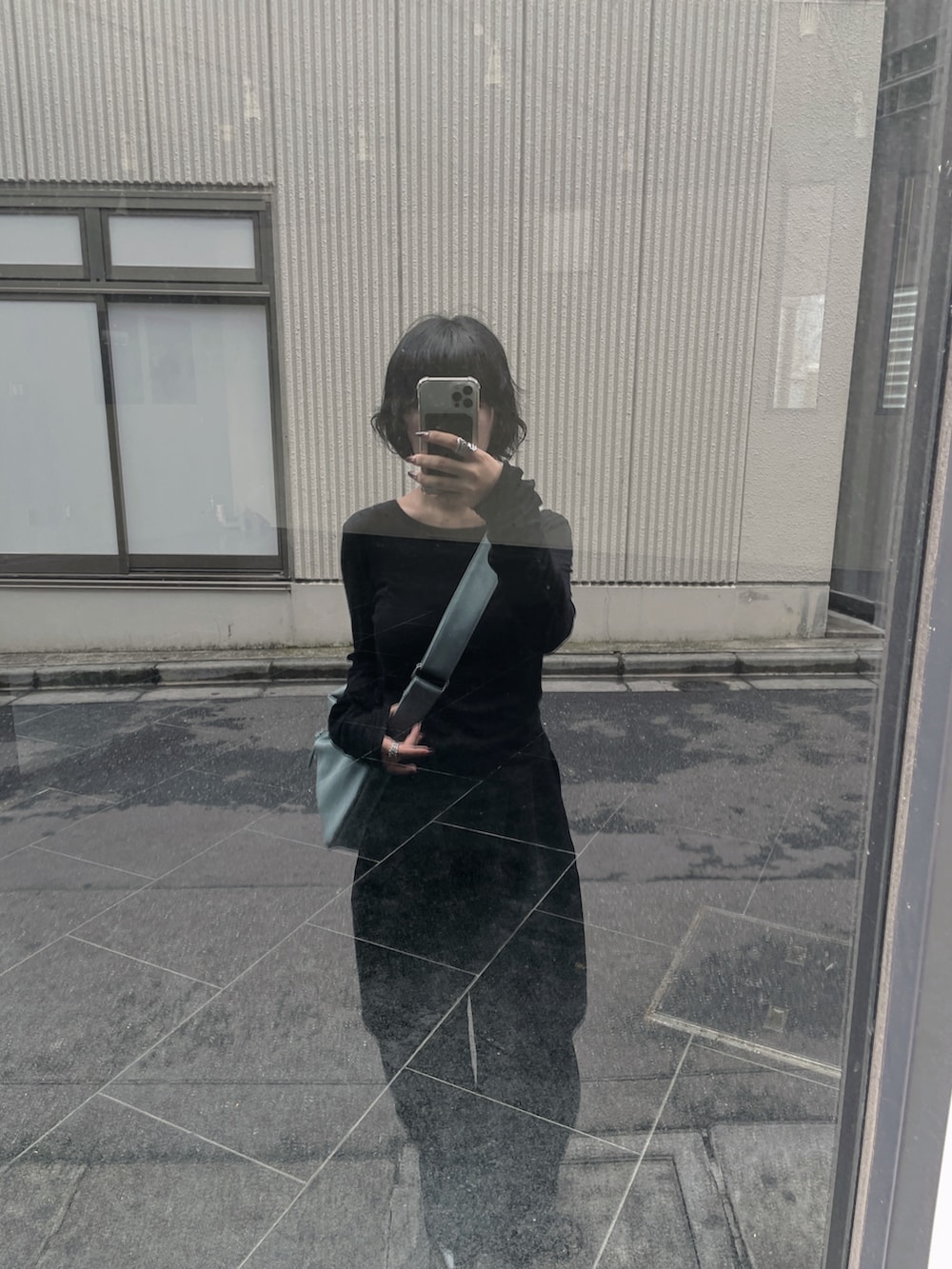 ブルー系のショルダーバッグ、ブラック系のTシャツ/カットソーを着用したレディースの夏コーディネートの2枚目の写真